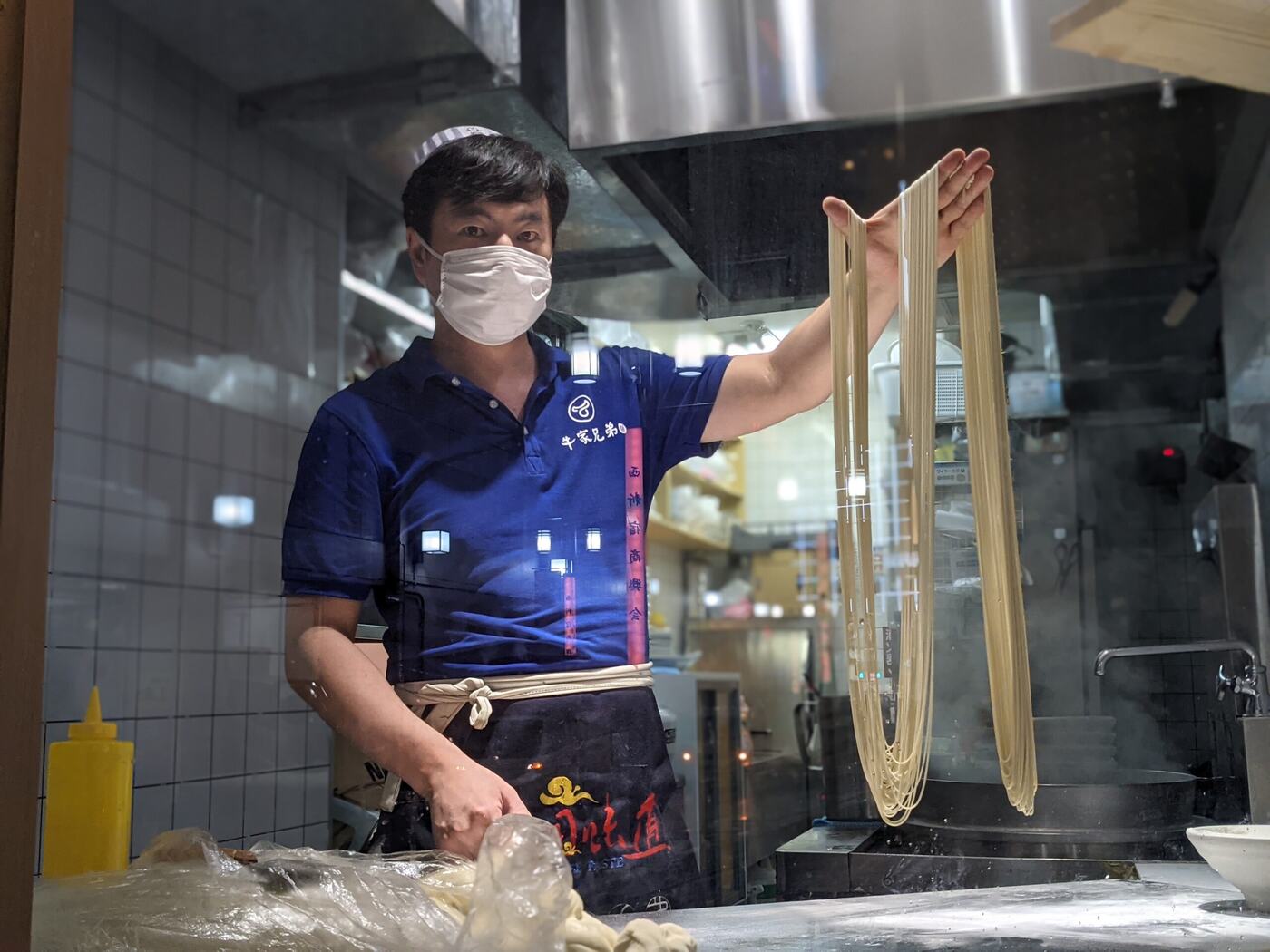 延ばしたての麺を見せる職人